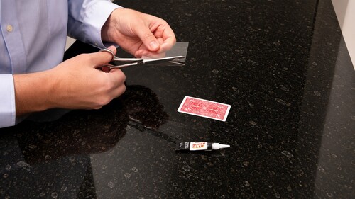 A clear plastic strip being cut for the floating card gimmick
