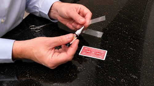 A clear plastic strip attached lengthwise to the back of a playing card