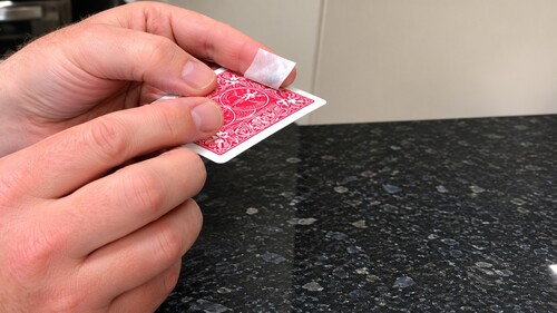 The clear strip extending slightly beyond both ends of the playing card