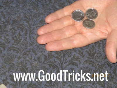 Coin is shown in hand with two other coins.