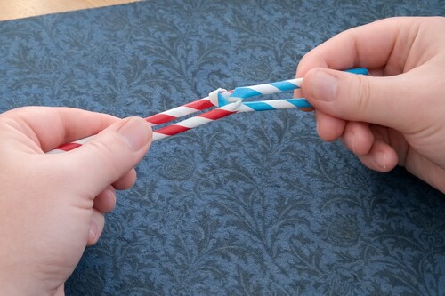 Drinking straws knotted together are made to magically seperate. loading=