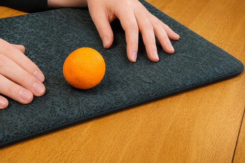 Orange is placed back on the table with the hands sitting naturally.