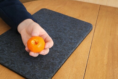Preparing a hidden thumb opening in one side of an orange