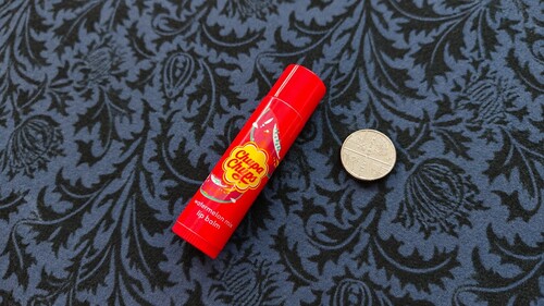 Stick of lip balm and a small coin used for the coin appearance trick