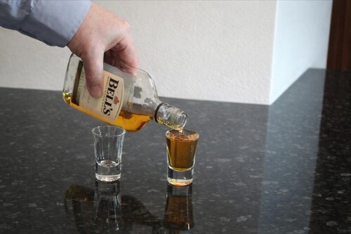 One glass filled with water and another filled with whisky