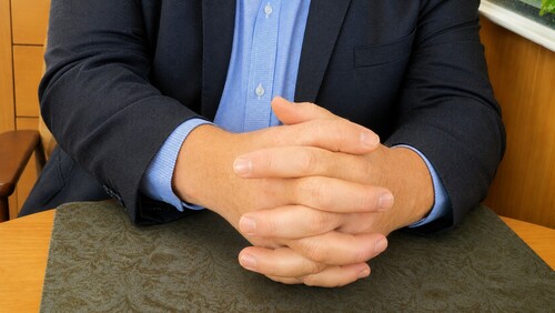 Spectator clasping hands together with fingers interlocked
