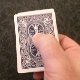 Correct thumb position is shown here when when handing back the playing cards.