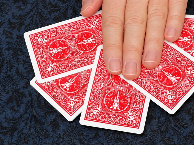 Playing cards attracted to the palm of your hand.