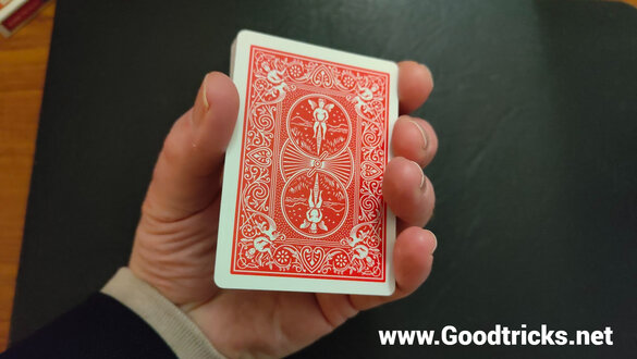 Playing cards held in hand in improvised mechanics grip ready to do some sleight of hand.