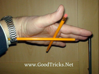 Image showing the secret positioning of a pencil slid under your watch strap to hold the other pencil in place.