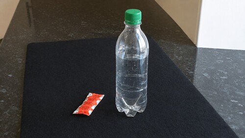 An empty clear plastic bottle and a sealed condiment sachet