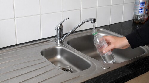 A clear plastic bottle filled almost to the top with water