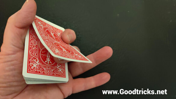 Pushing up playing card with finger to create spring tension.