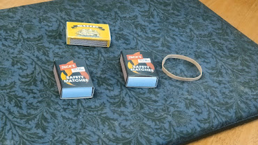 Three matchboxes and a rubber band needed for the trick