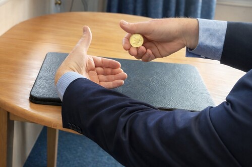 Coin is shown be transffered hands but is secretly retained in the original hand.
