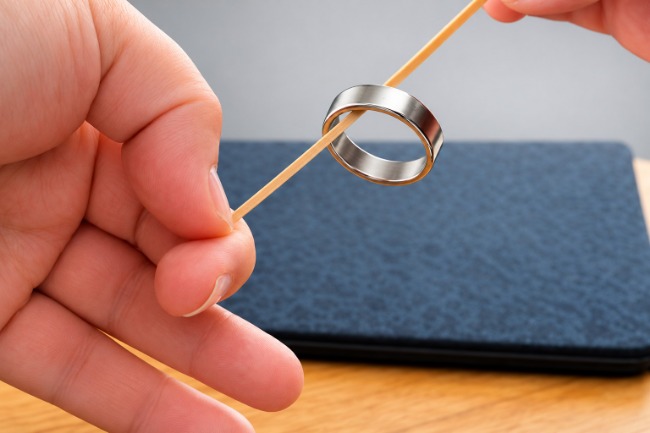 Finger ring climbing up a rubber band.