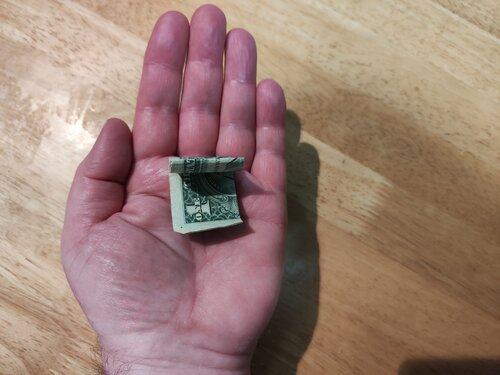 A dollar bill folds itself into quarters.