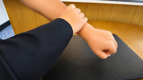 The spectator's closed hand being gently turned palm-down
