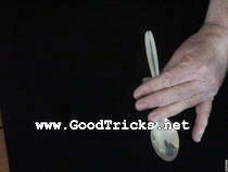 Hold spoon with other hand near the bowl.