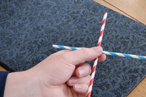 One straw held horizontally above another straw