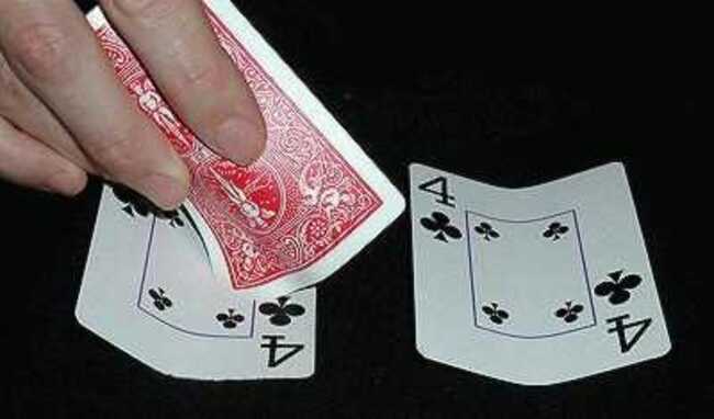 Three playing cards being used for a Three Card Monte routine
