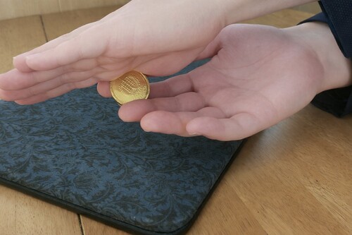 Coin being clipped between the fingers during a Thumb Palm production