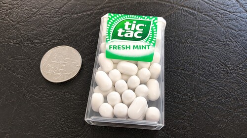 A box of Tic Tac candies and a coin