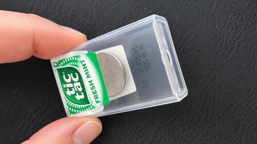 Coin being slid back under plastic cap.