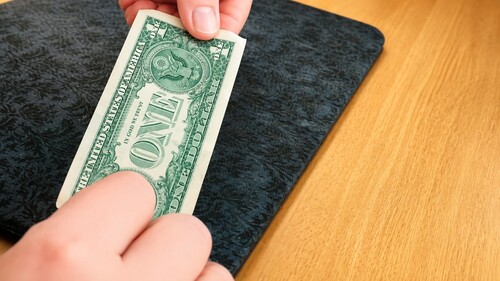 Dollar bill being borrowed for a close-up magic trick