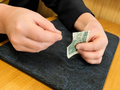 A money bill with a piece being torn off.