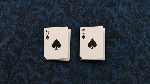 Two playing cards folded lengthwise and widthwise into quarters