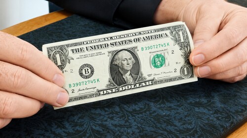 Dollar bill stretched between both hands to hide the tear