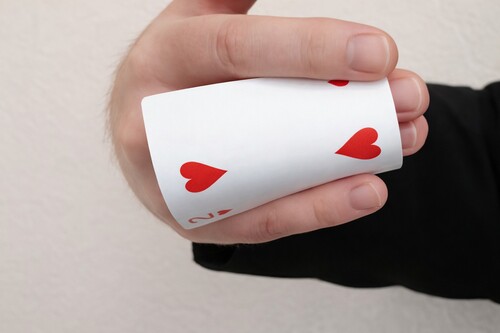 Playing card concealed behind the hand after the vanish