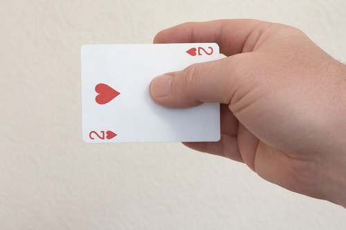 Playing card held at the fingertips in the starting position for the vanish