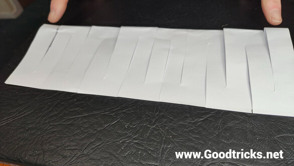 Making cuts along a sheet of paper.